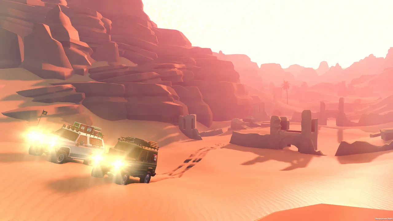 Two off-roaders with bright headlights drive across orange sand past ruined mud-brick walls and red rock cliffs, with a palm tree in the distance.
